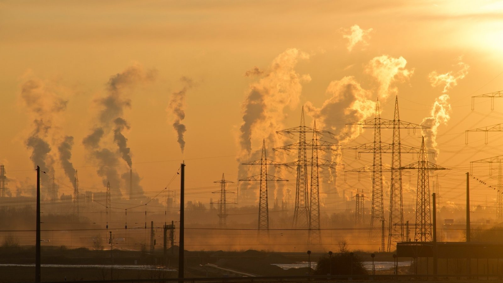 Electric Towers producing smoke during sunrise with a golden background