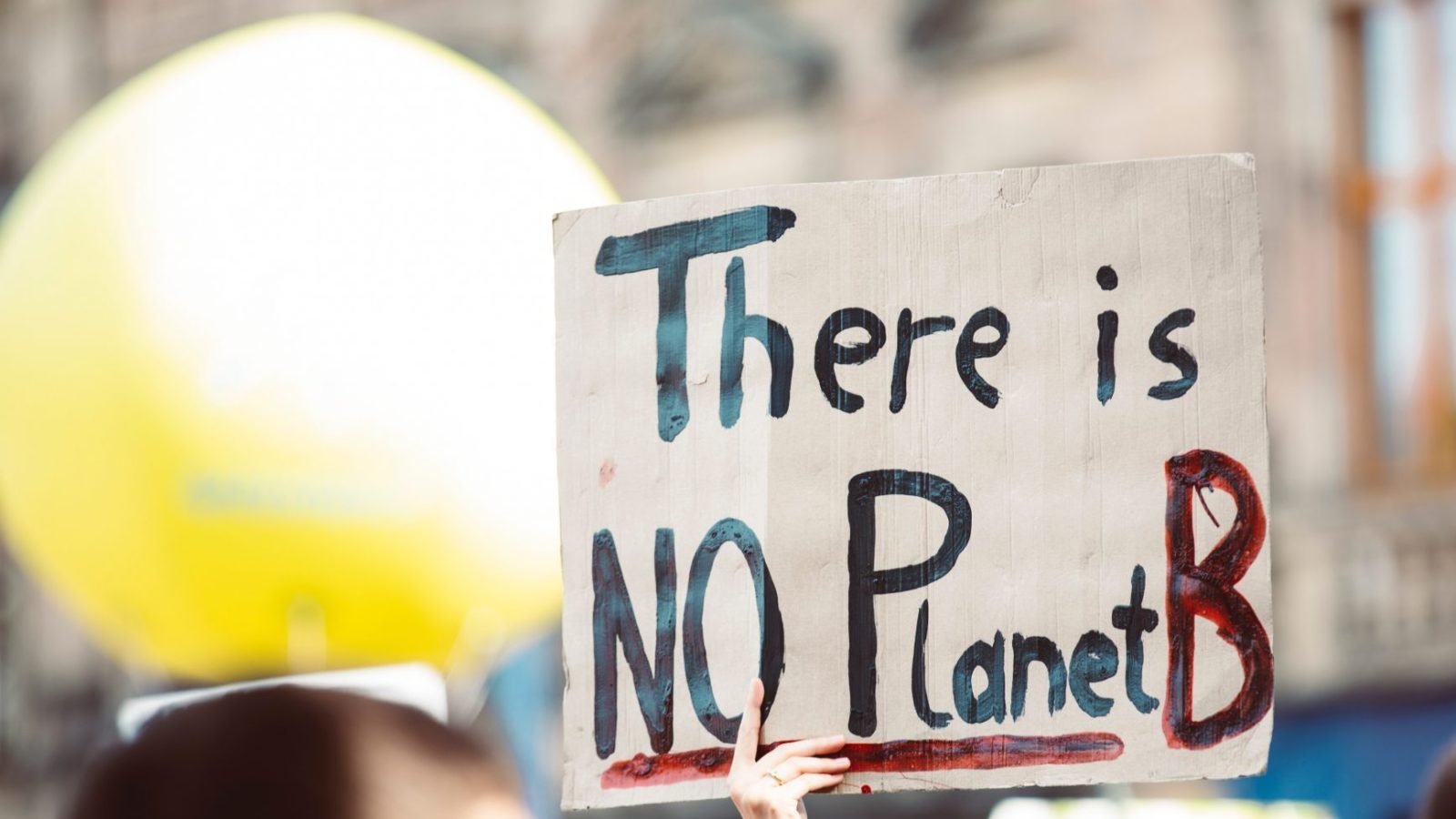 A protest sign that says in black ink