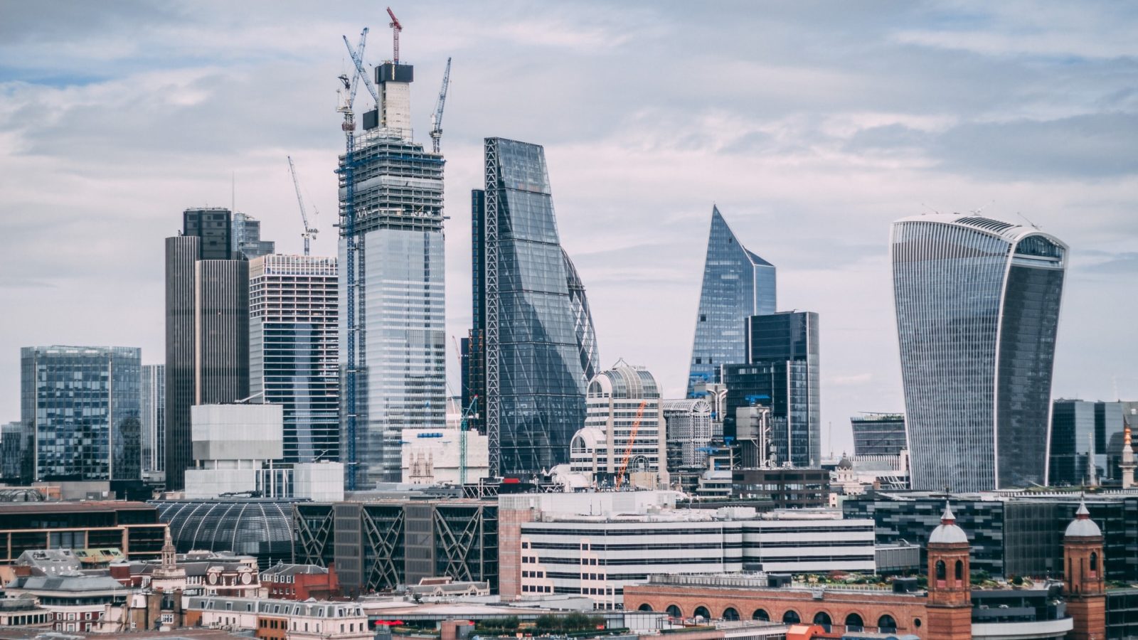 High rise buildings in London, pictured against a cloudy sky