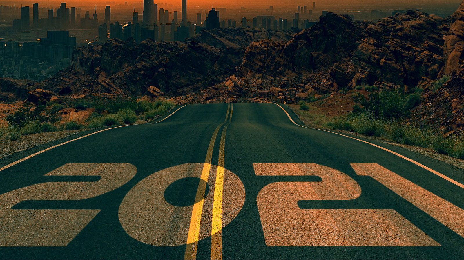 A road with 2021 painted on it disappears into the distance