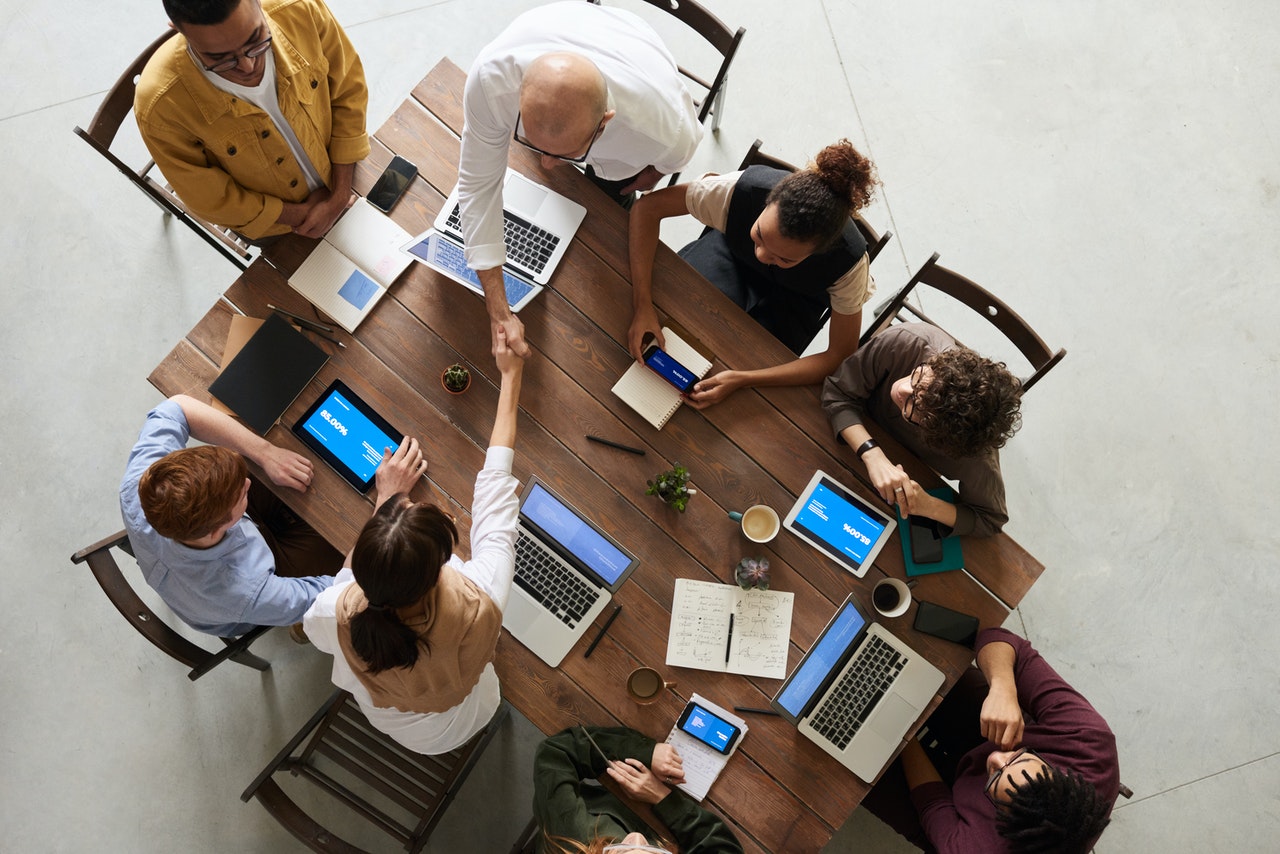 Overhead shot of people working together at a large brown desk