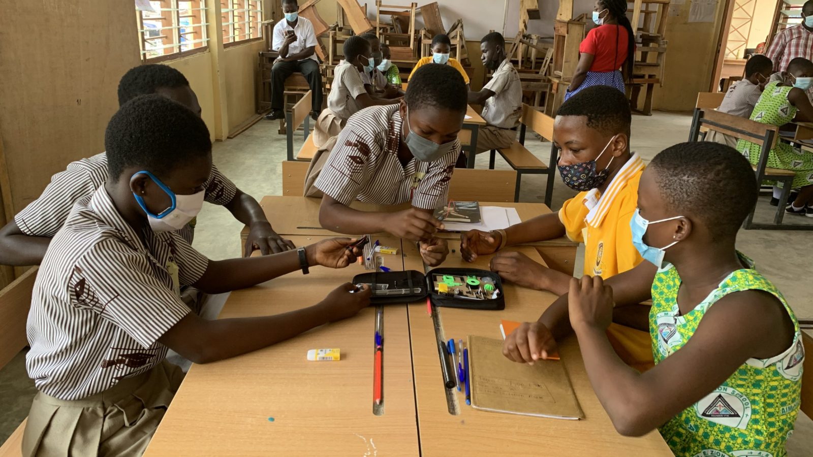 Ghanaian school children sit around a table in class