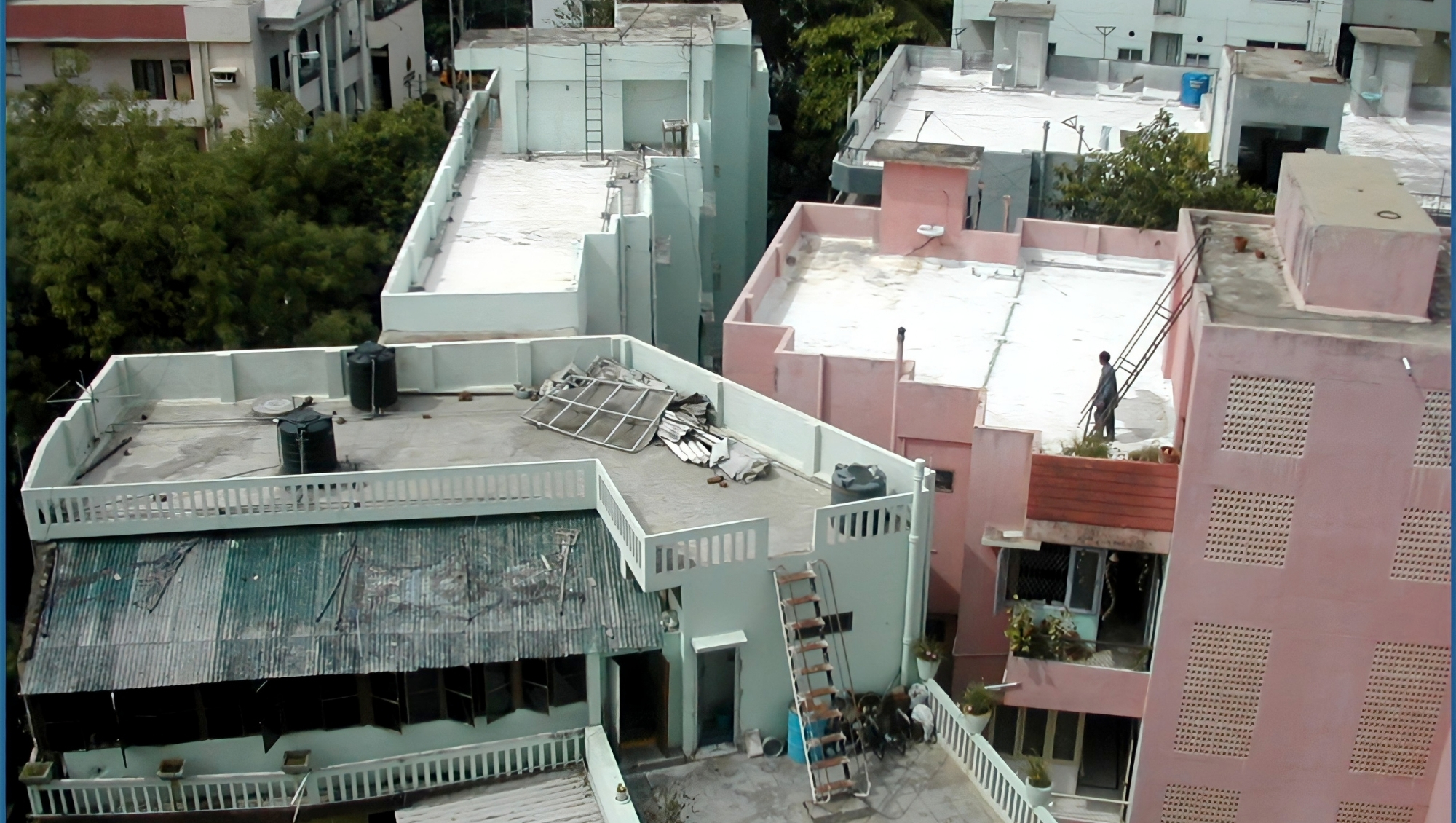 Aerial view of flat roofs in India, some painted white to reduce heat absorption
