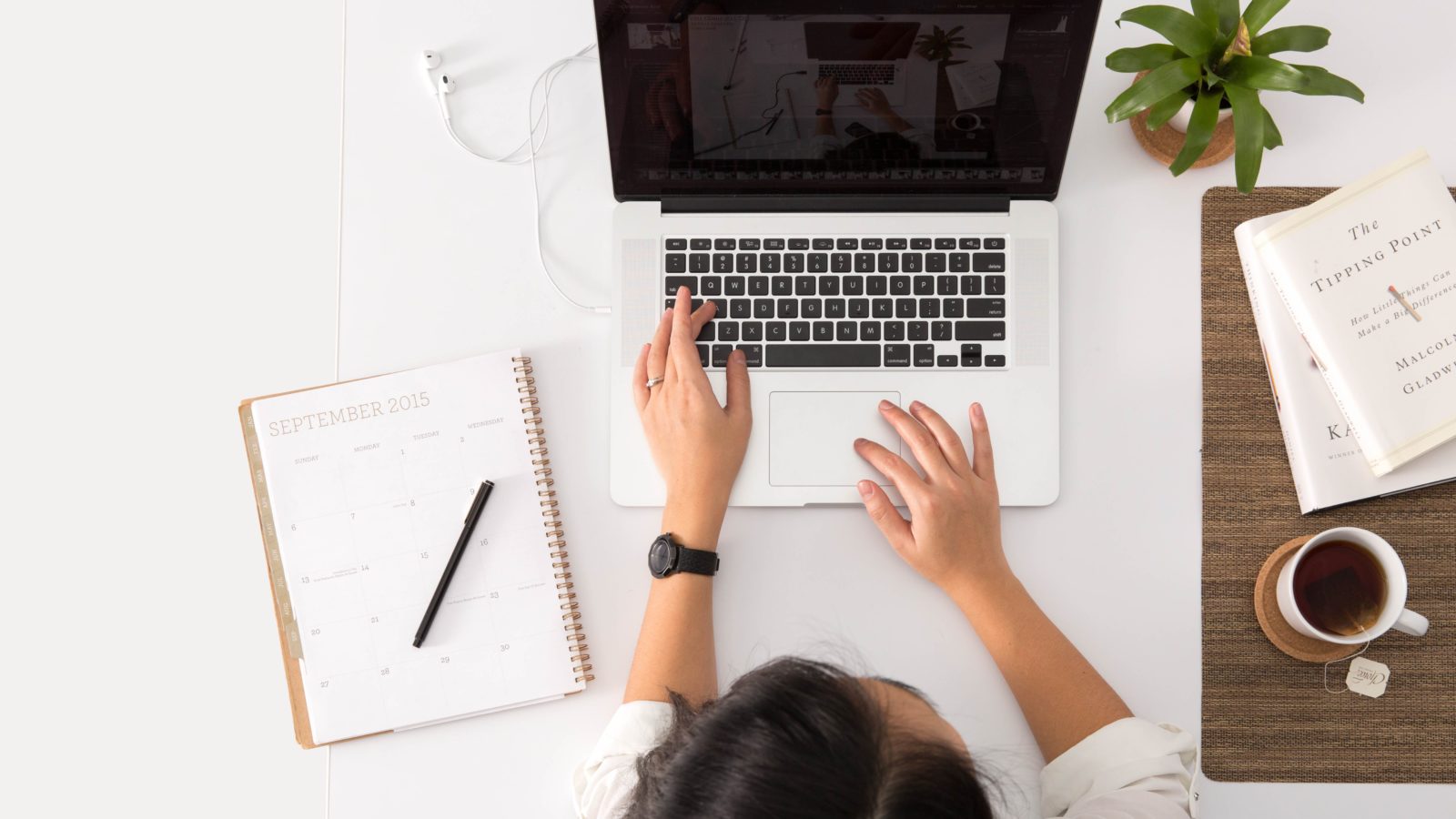 An overhead view of a woman working on a laptop