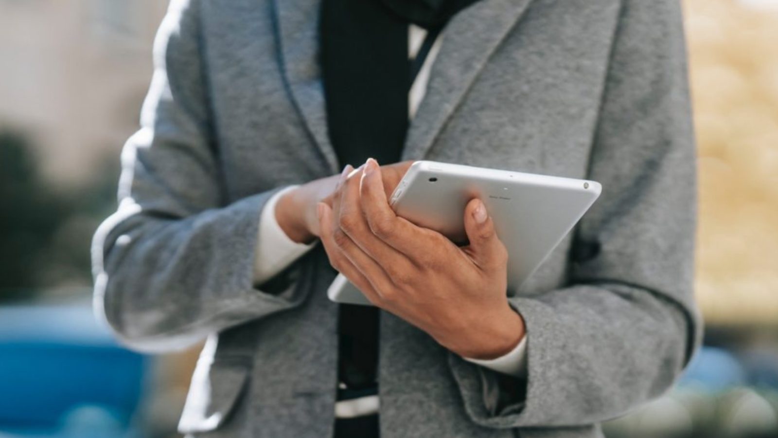 Close up of person stood holding a tablet computer