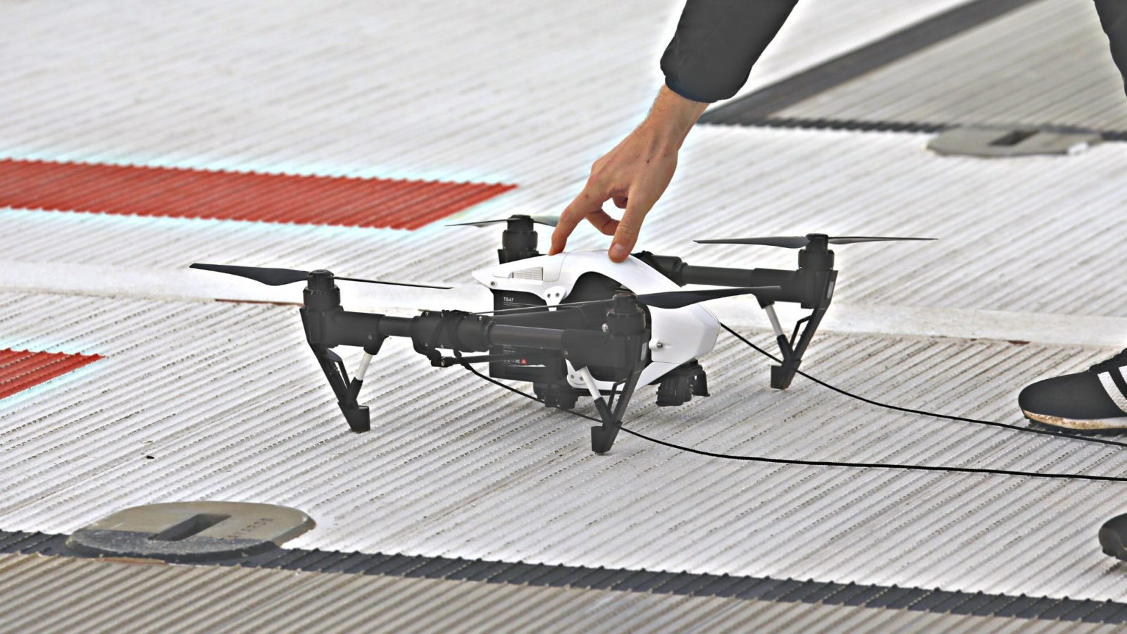 Drone on the ground steadied by a hand resting on the top
