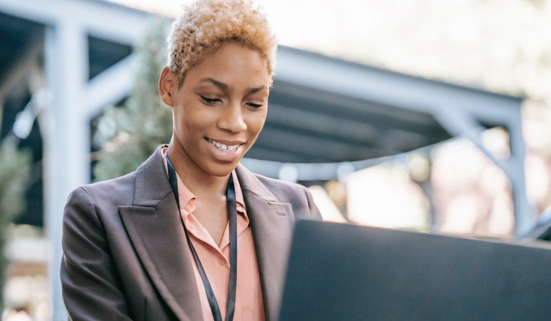 A black woman smiles while working at her laptop|Screenshot of the careerchat service on an iPhone
