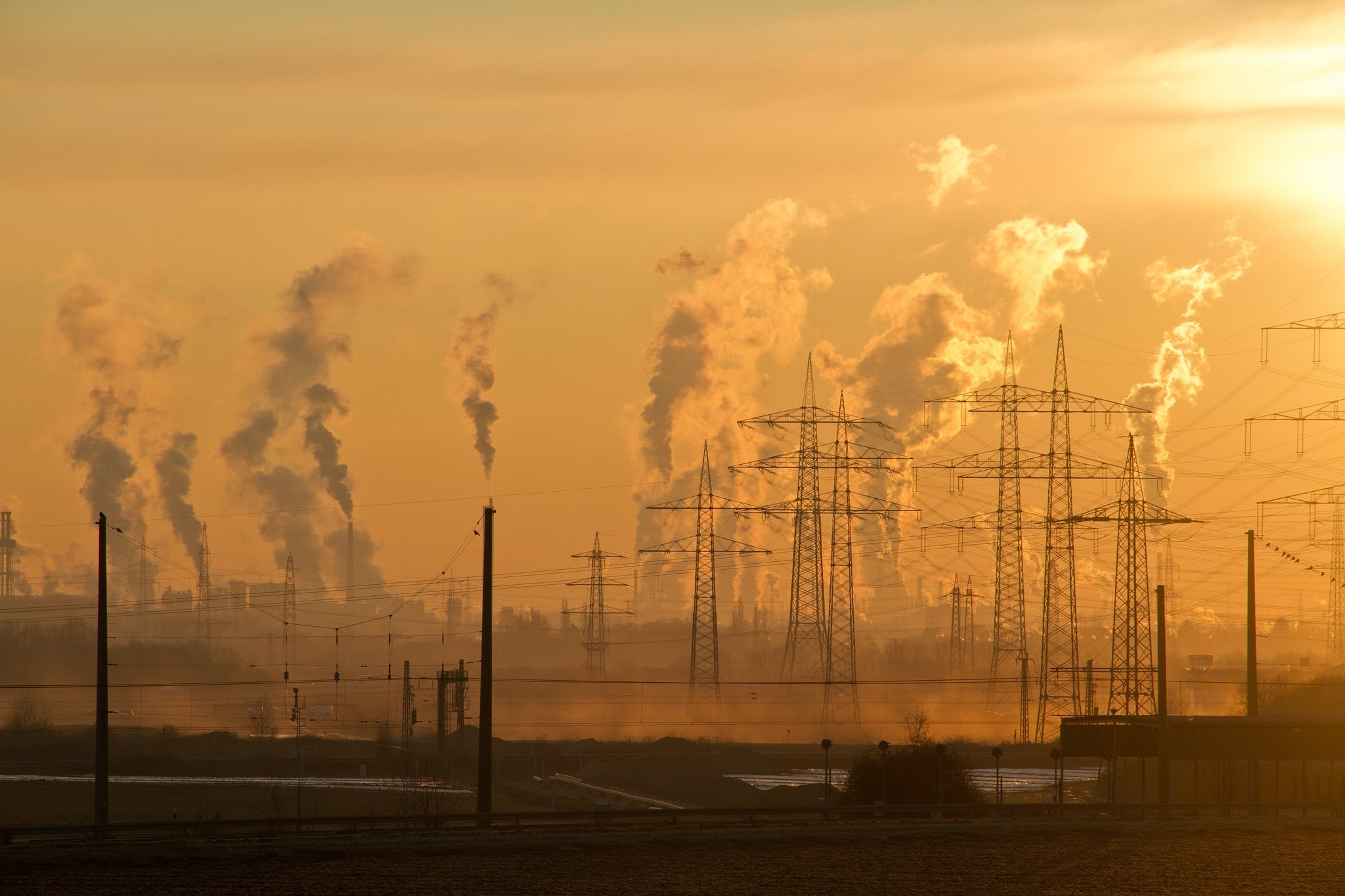 Electric Towers producing smoke during sunrise with a golden background