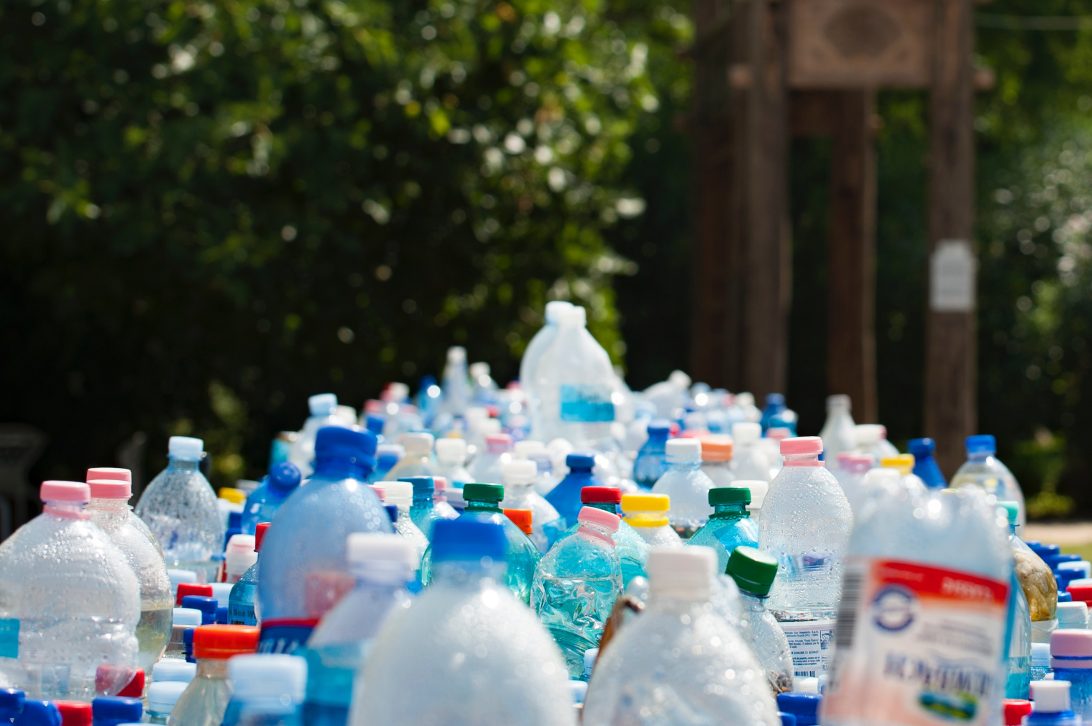 Empty plastic bottles on a table outside|European Social Innovation Competition logo