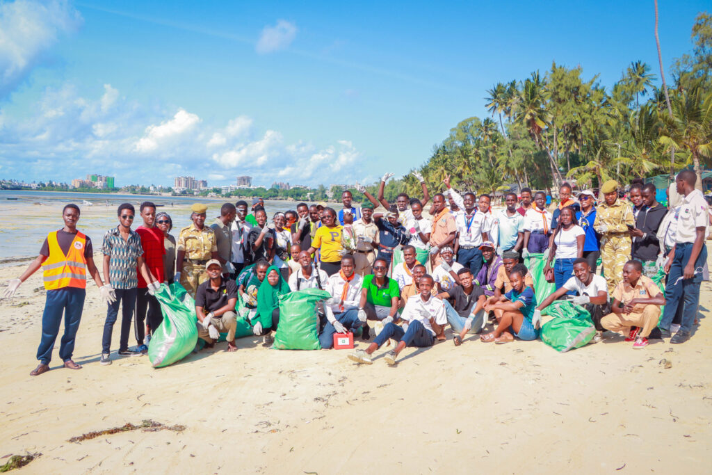 A crowd of people in Mombasa on the beach collecting plastic in the beach.|MPP Incubator teams meet the US Ambassador to Kenya