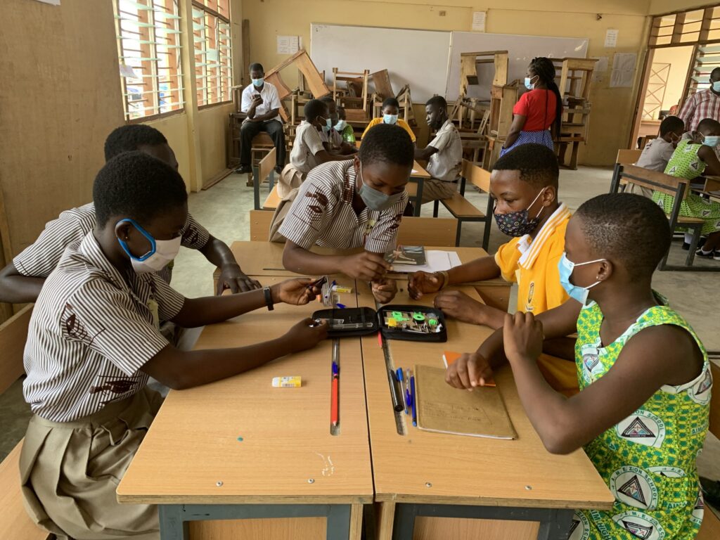 Ghanaian school children sit around a table in class|Dext logo|Dreamoval Foundation logo|Fondation Botnar logo|Foundervine logo|Ghana Education Service logo|Mest logo|Ministry of Education logo|Young people being presented with a giant cheque on stage|Team Beyond Creation|Team Alpha S|Team Amigos|Team Best Brain|Team Big Sharks|Team Brainiacs|Team Democratic|The Genius Six Ashanti team