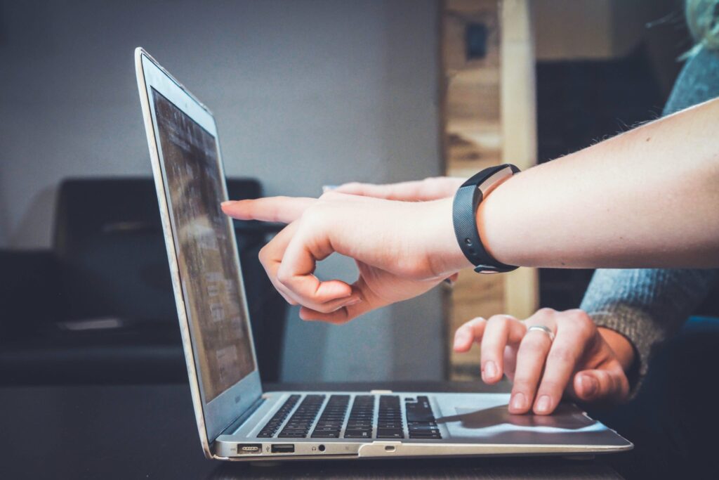 Close up of two people's hands at a laptop|Black woman with white braids