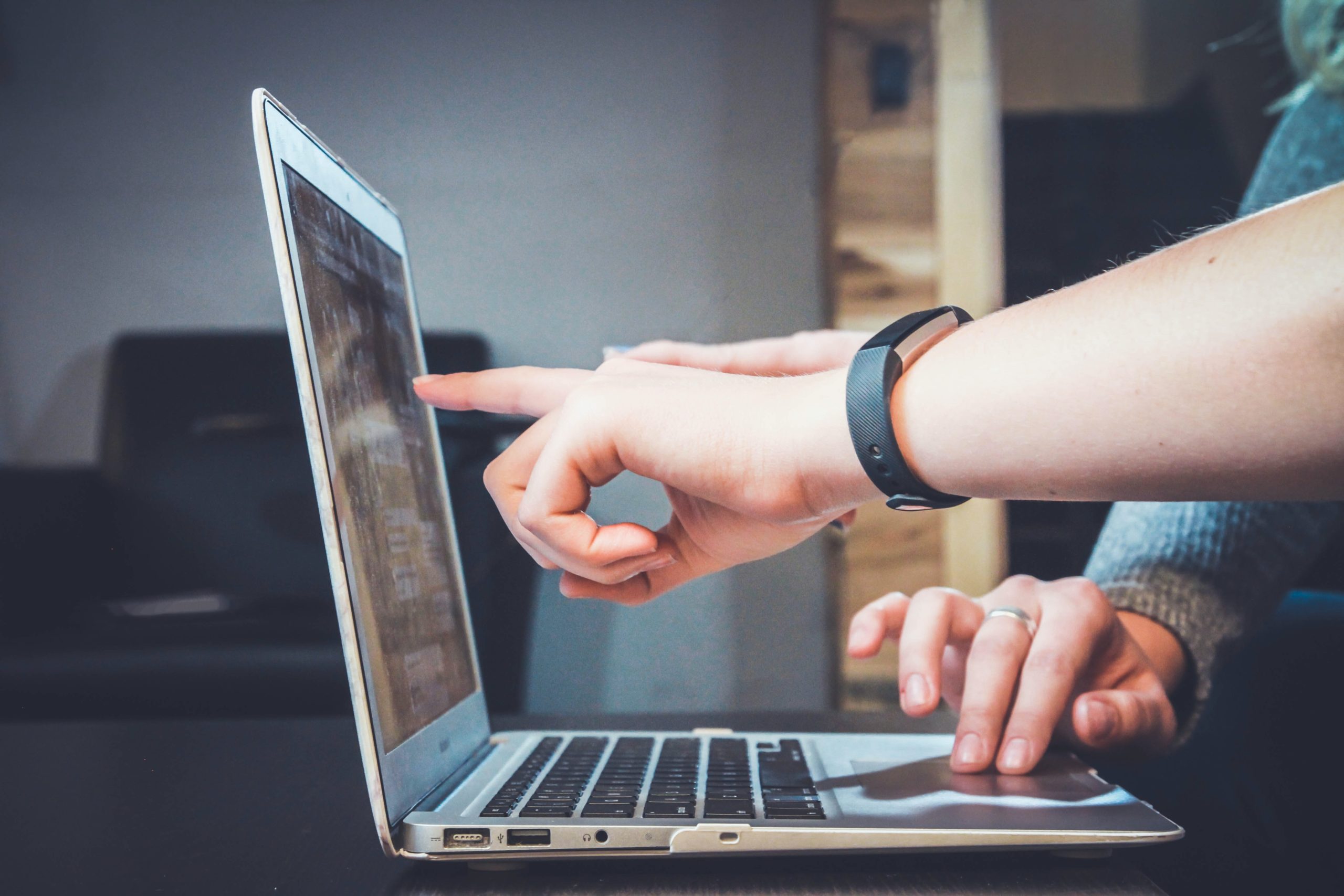 Close up of two people's hands at a laptop|Black woman with white braids