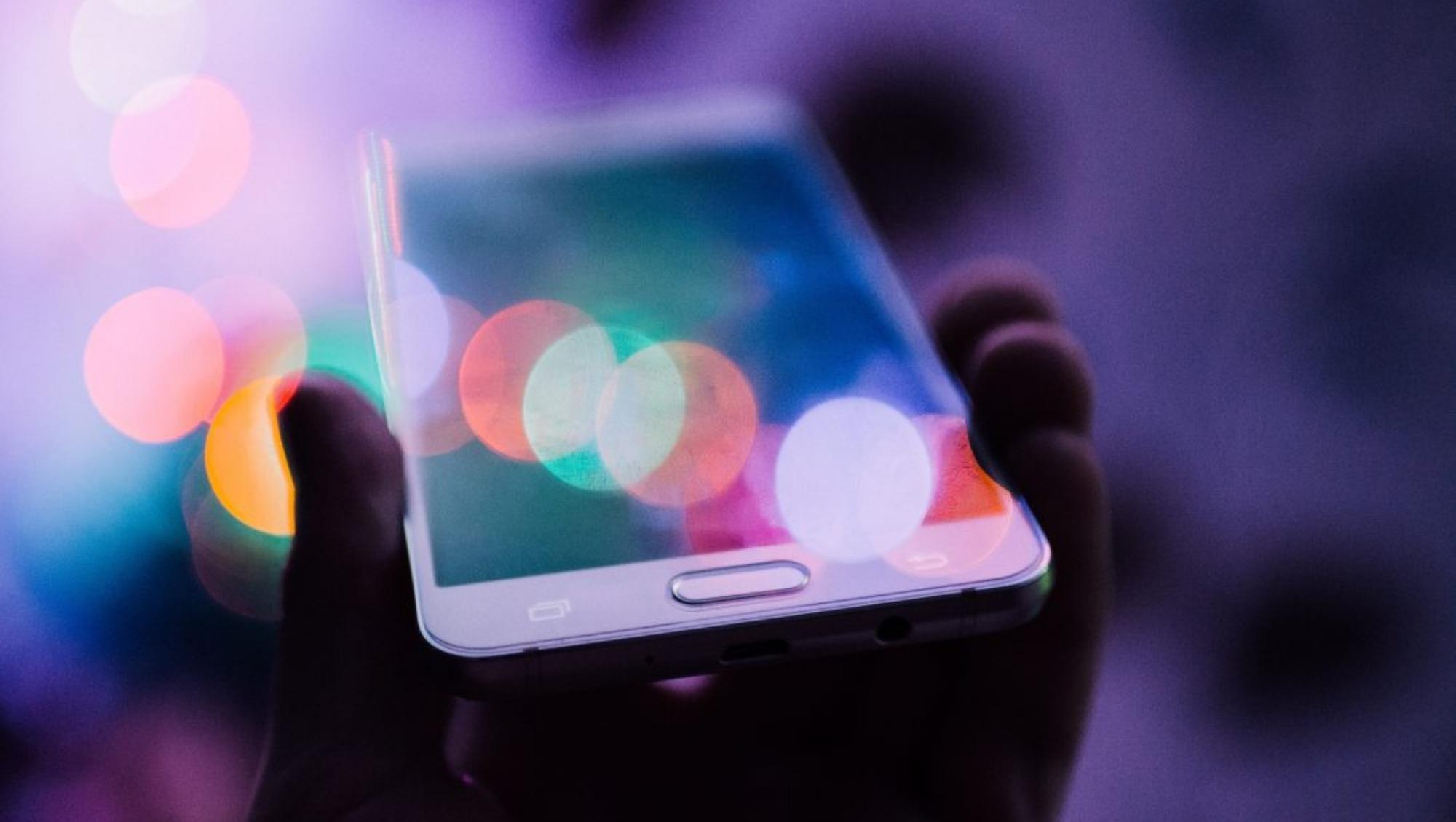 Light dances on an outheld mobile phone