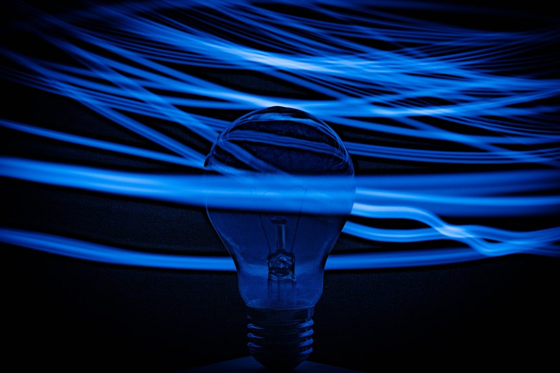 Blue and white light filaments and lightbulb|Grey and white smart home device|Wind turbine against a blue sky|The International Space Station||A contactless payment being made via a mobile phone