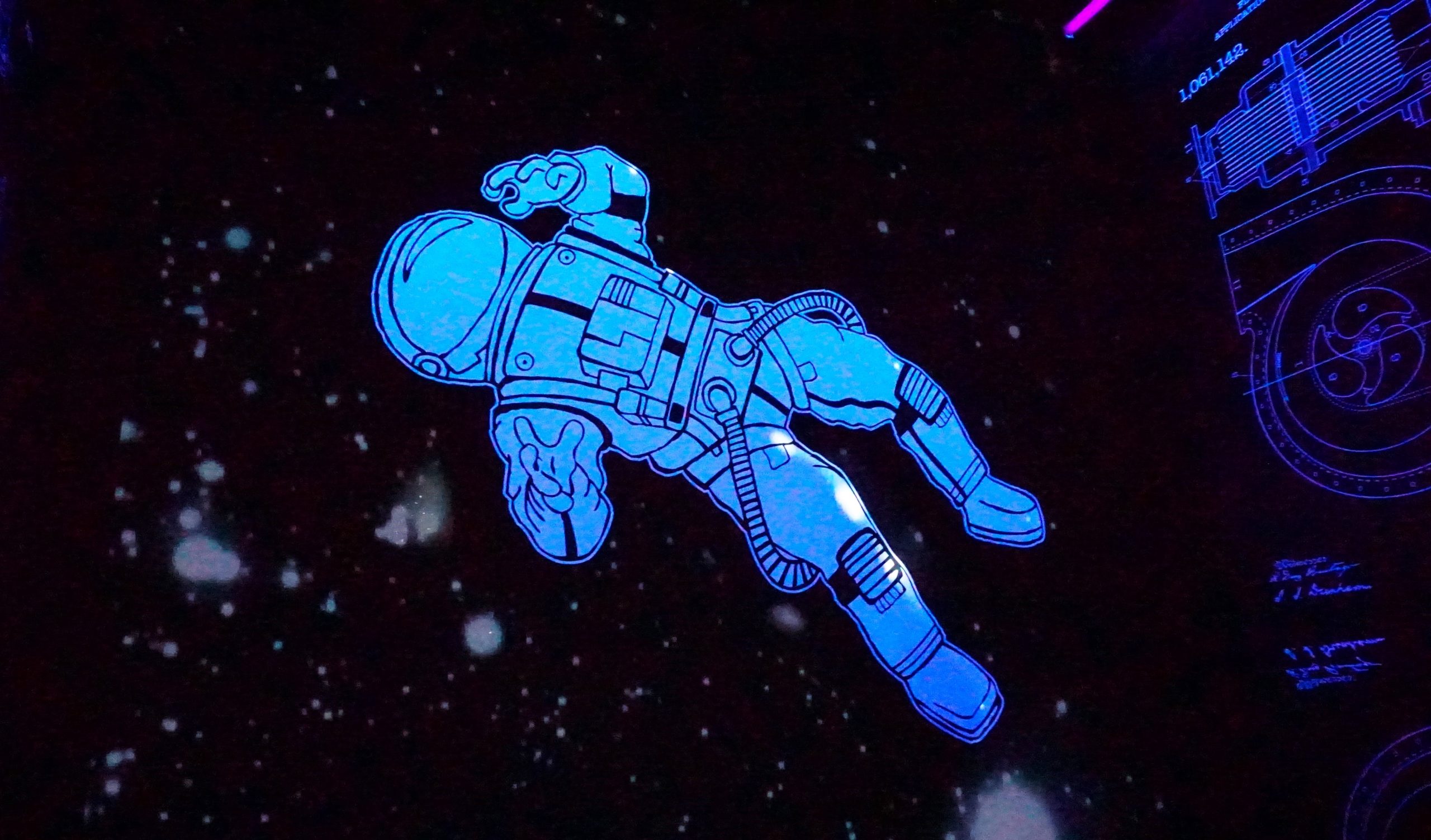 A cartoon -like drawing of an astronaut floating in space|President John F Kennedy standing on a podium looking off and smiling to the right|An astronaut stands on the moon