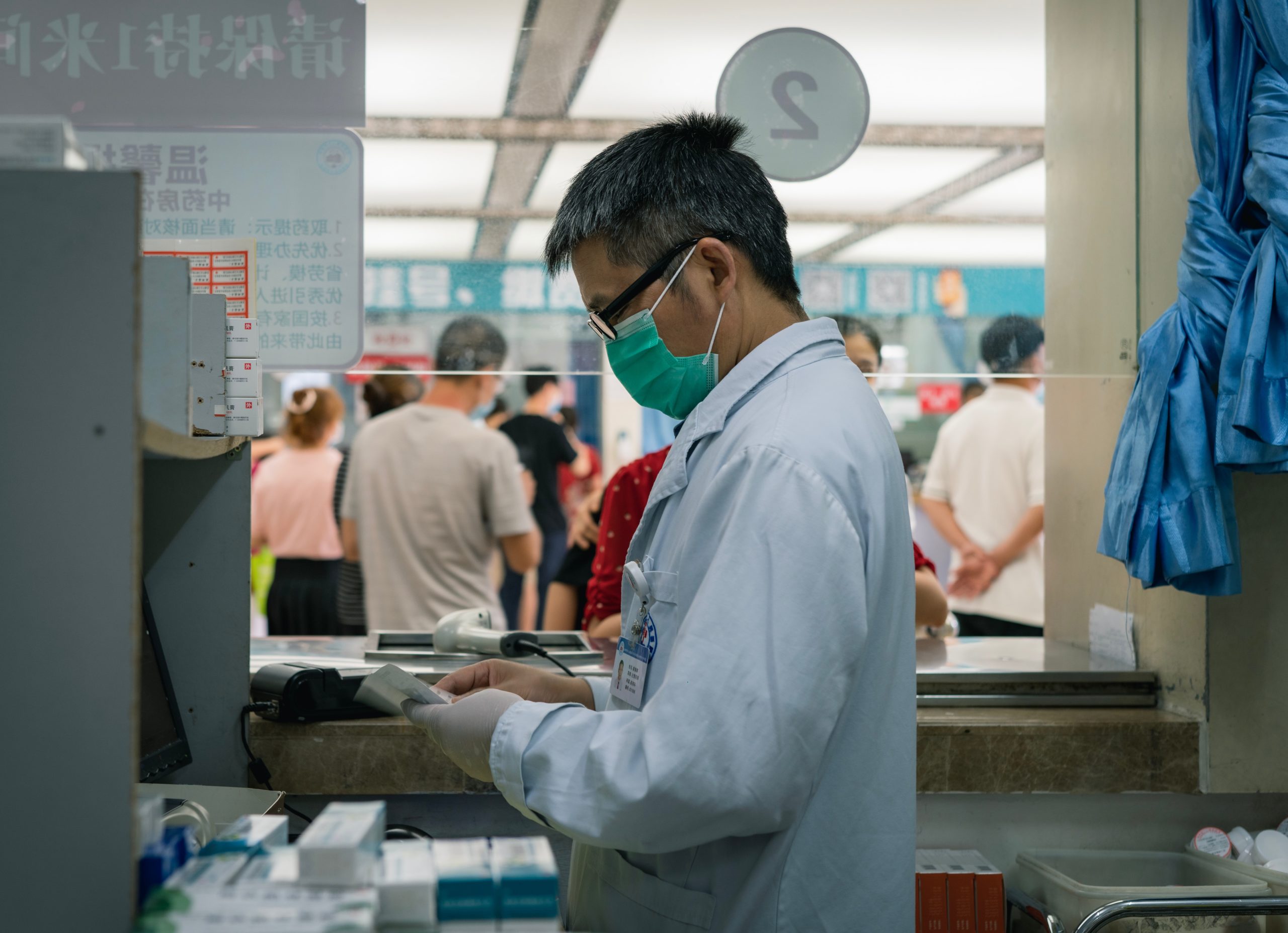 Pharmacist in mask prepares prescription|Diagram about rare patient statistics. 'The average rare disease patient: Consults with 5 doctors