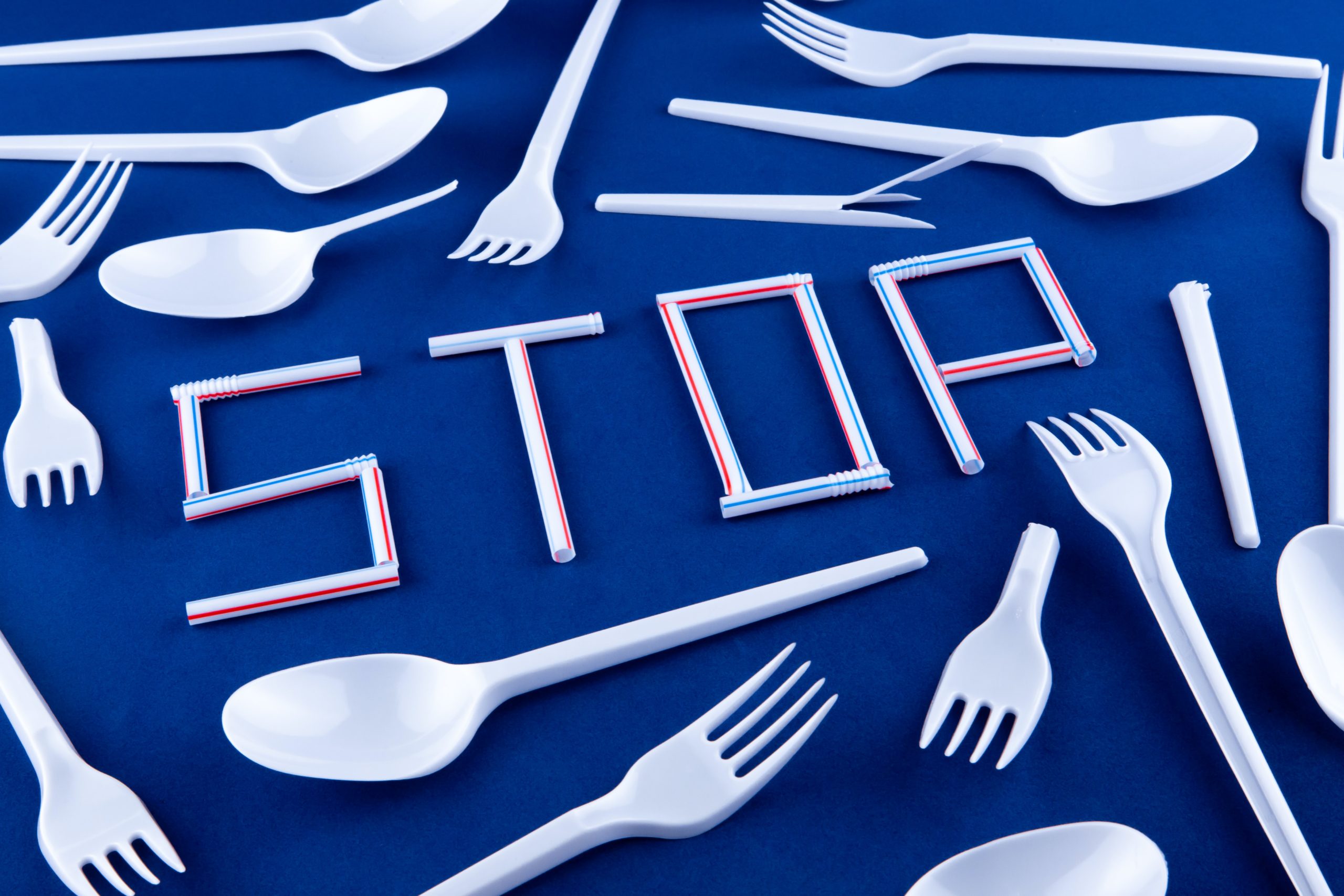 A table is scattered with plastic cutlery and plastic straws spell out the word 'STOP'|An infographic shows how we can promote changes in plastic use in the community