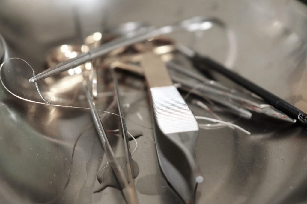 A variety of steel surgical instruments laid out on a tray