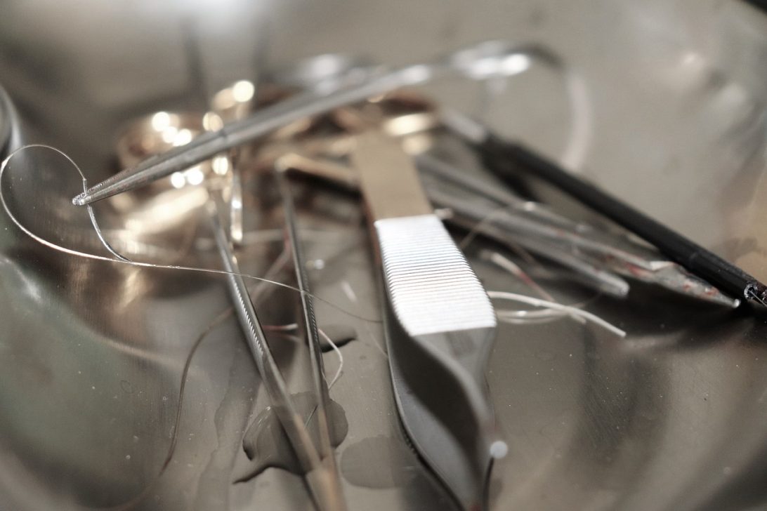 A variety of steel surgical instruments laid out on a tray