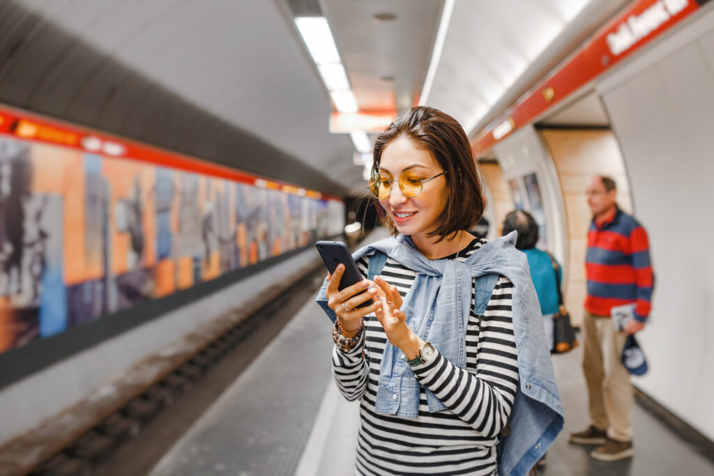 Woman using her smartphone on a public transport platform