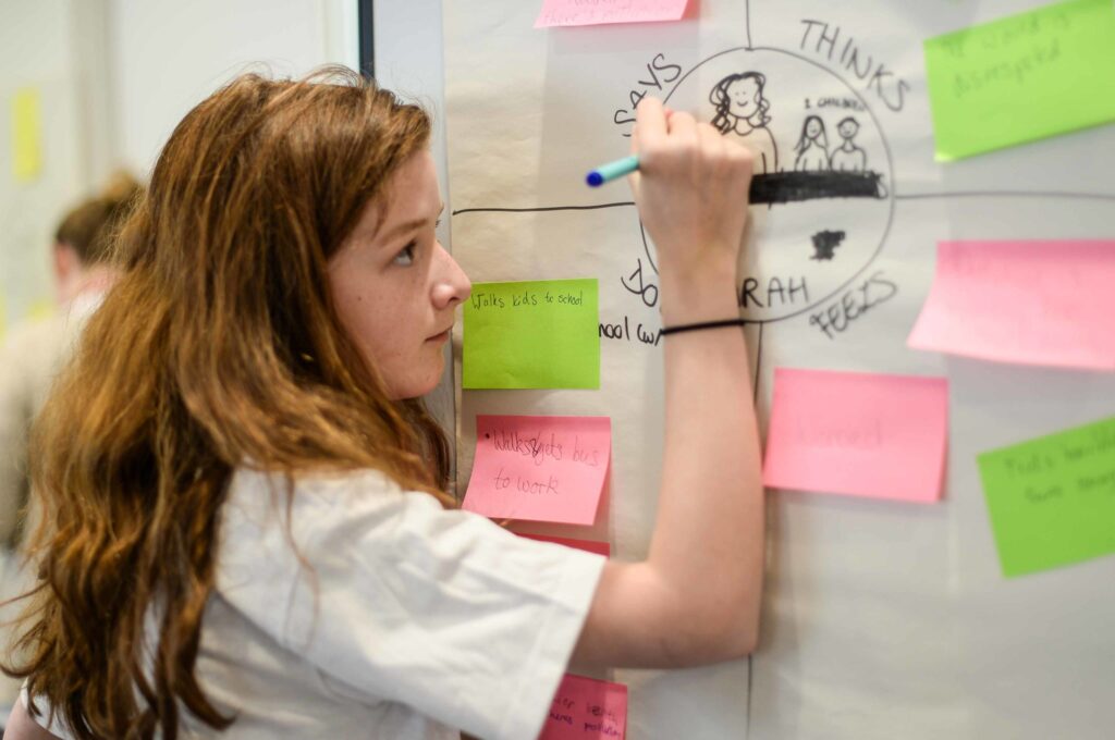 Teenager writing thoughts on post-its on a wall