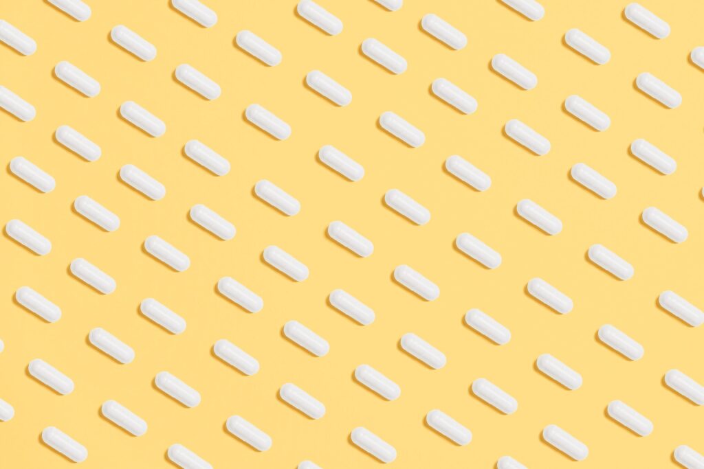 White pills across a yellow background|A Series One box. The text reads More Data. more analysis. More lives saced.