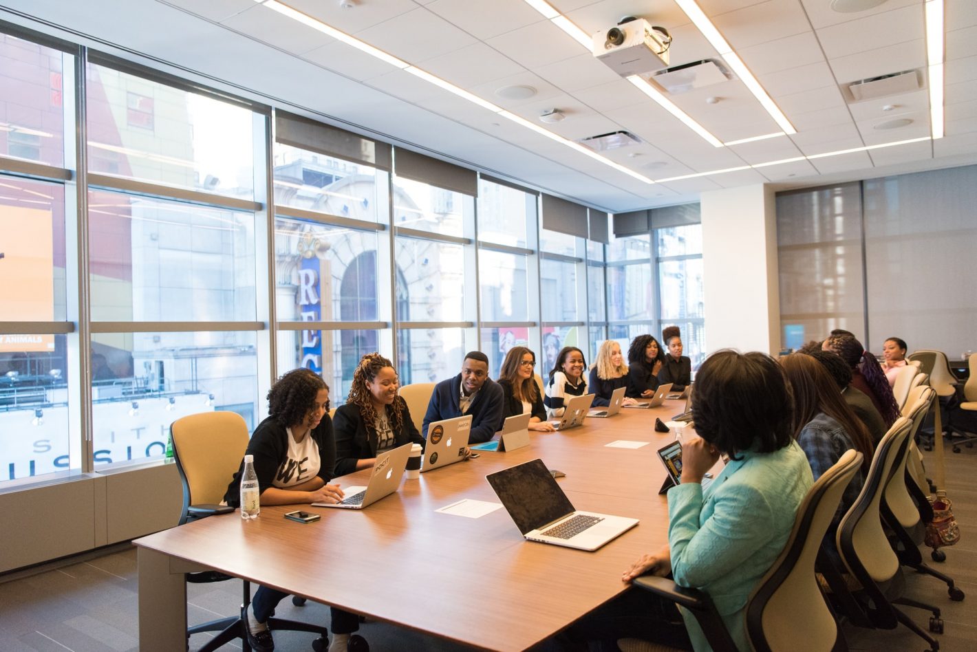 Group of people sat at either side of a long desk