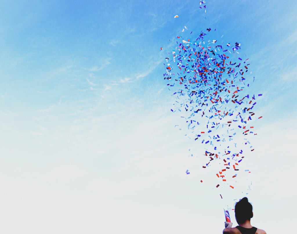 silhouette of a person releasing a party popper into the sky
