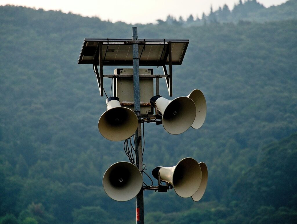 white speakers against a mountainous scene