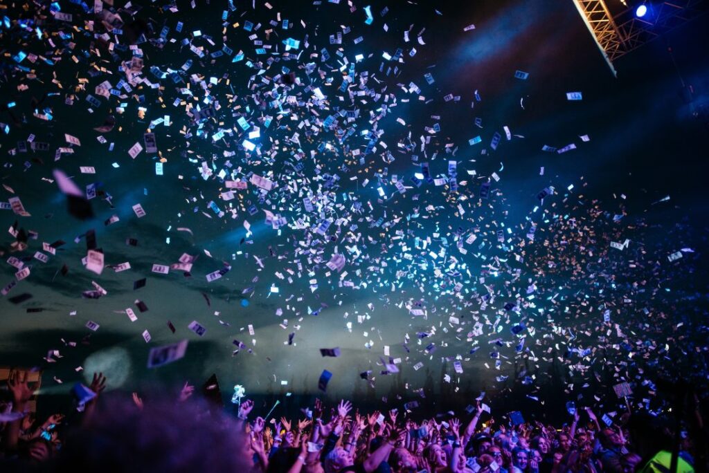 Confetti coming down from the ceiling at a celebratory event|The Rendcomb College winners face the camera