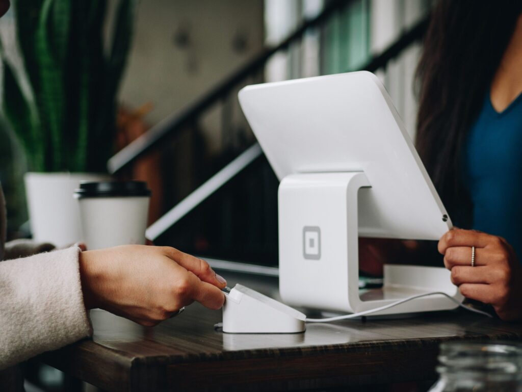 Close up of someone paying by contactless|HSBC logo|Lloyds Bank logo|Santander logo|Barclays logo|RBS logo|HSBC logo|Lloyds bank logo|RBS logo|Santander logo|Barclays logo