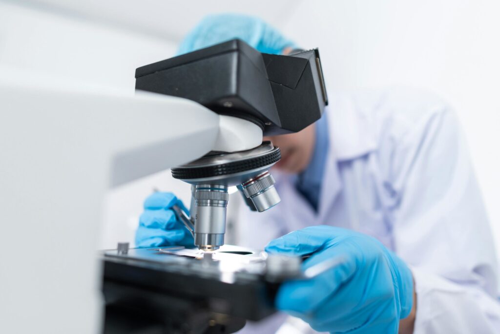 An image of a man in a lab using a microscope.