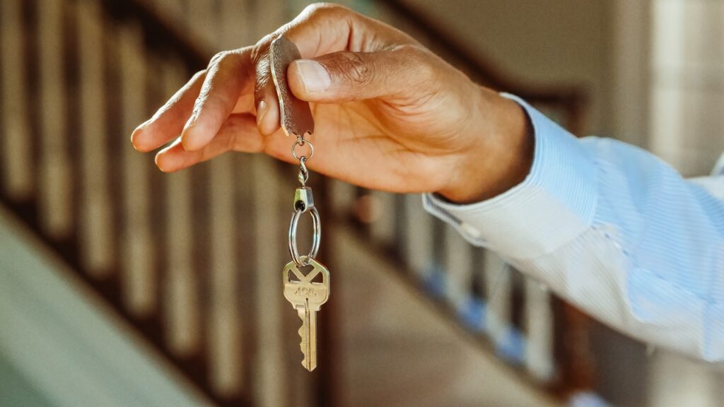 A close up of a person holding a silver key on a keyring|Mojo logo|A close up of someone using the MortgageScore app