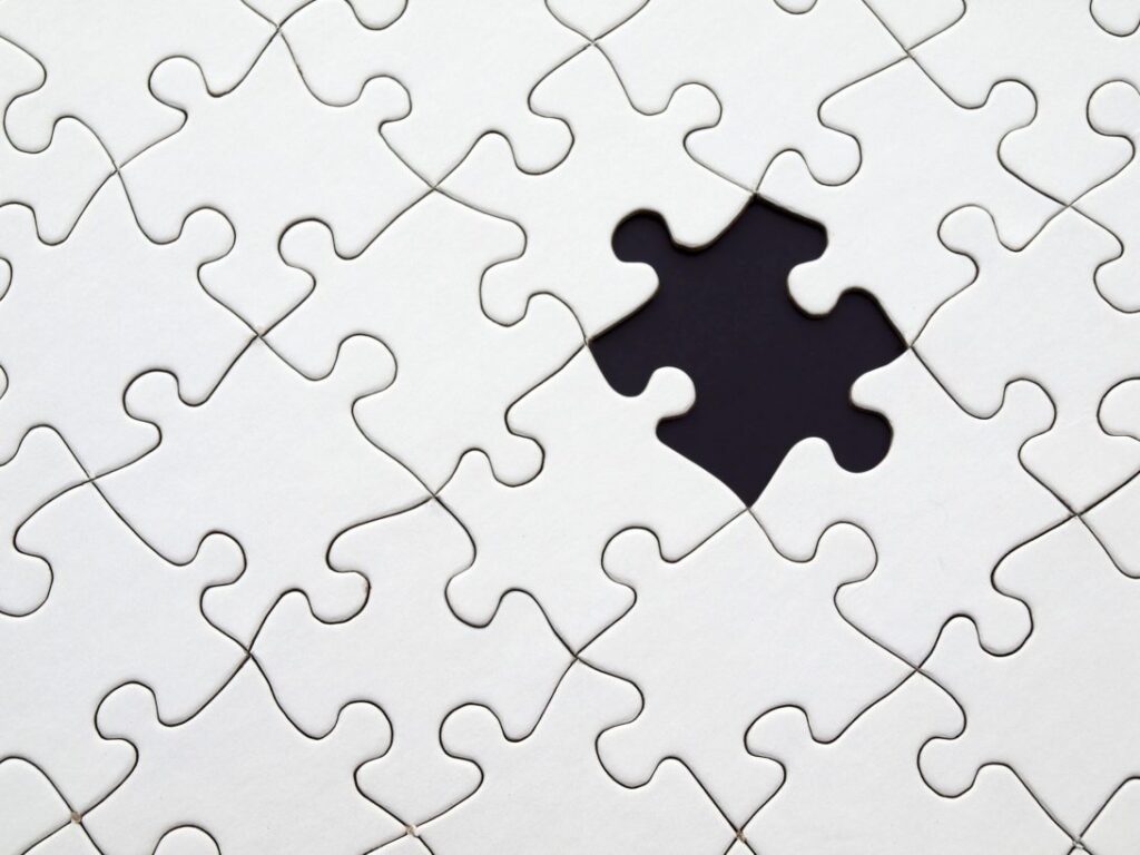 A white jigsaw has one piece missing